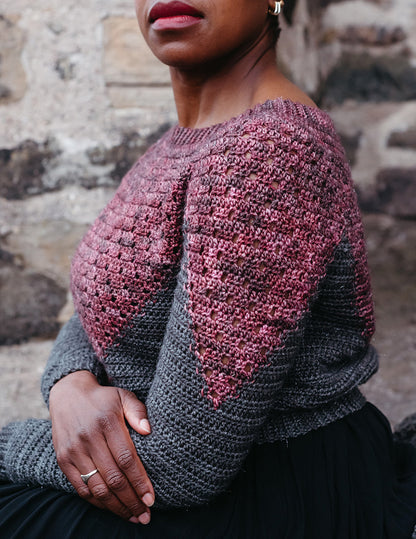 Astronomia is a intarsia colourwork pullover. The jumper begins from the top in maroon with eyelets, and the colour extends in a point down the front, back and each sleeve.