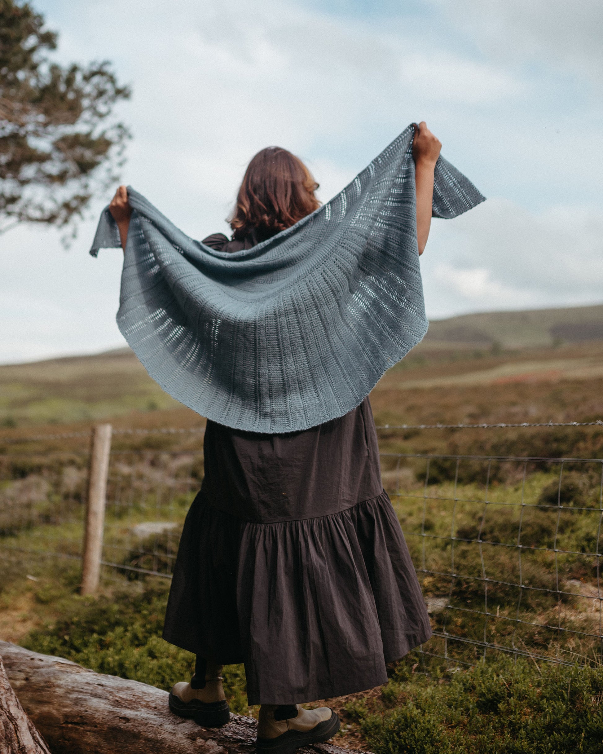 Glór is a large half circle shawl with rays of Tunisian stitch panels radiating from the centre.